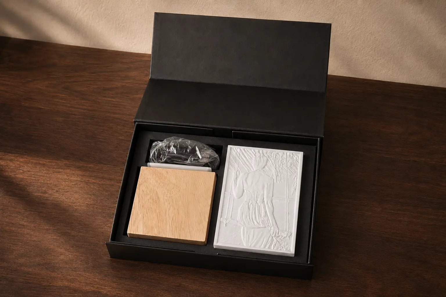 Geöffnete schwarze ArtLight Geschenkbox mit Holzfuß, Foto-Relief und verpacktem Kabel