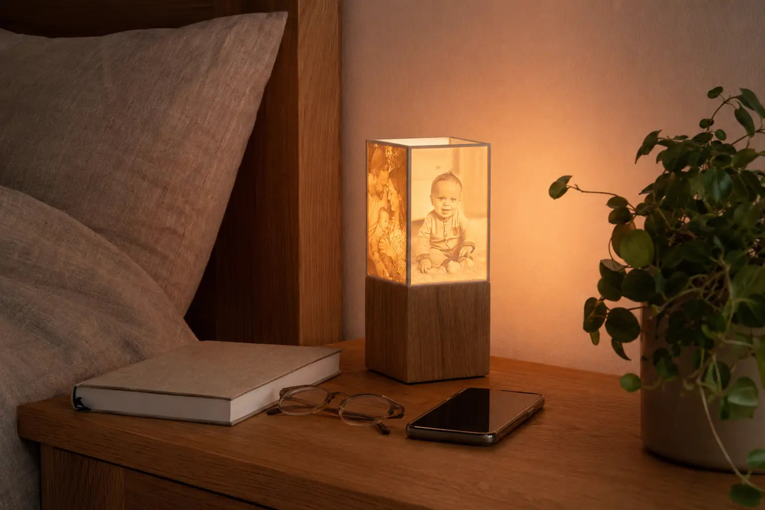 ArtLight Fotolampe auf einem Nachtkästchen neben Buch, Brille und Smartphone als Größenvergleich
